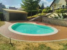 Aménagement de contour de piscine avec des pavés en bordure dans une maison à Andrézieux